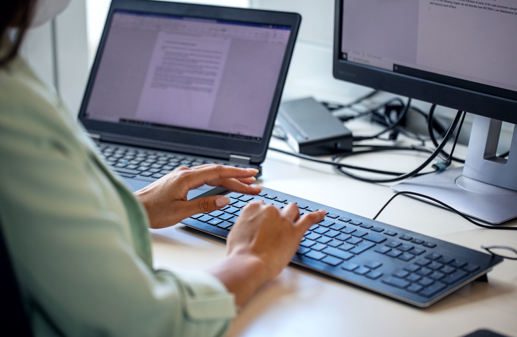 KI-basierte Redaktionsprozesse Person schreibt am Laptop