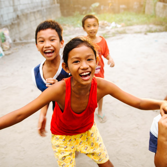 Asiatische Kinder spielen und lachen drau&szlig;en