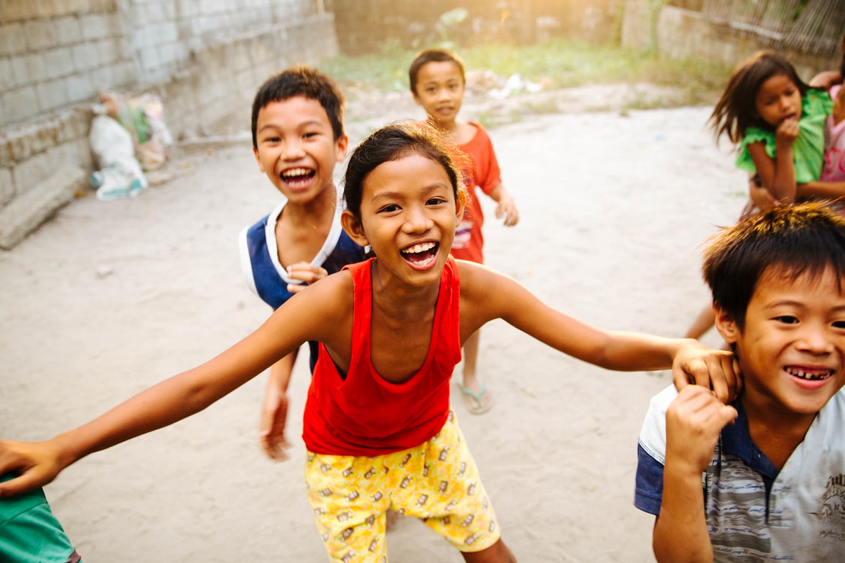 Asiatische Kinder spielen und lachen draußen