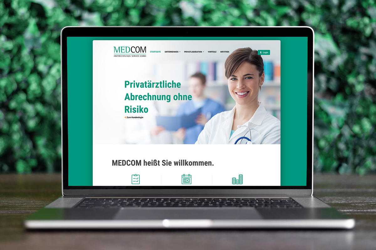 Laptop auf Holztisch mit Screenshot der Medcom-Website